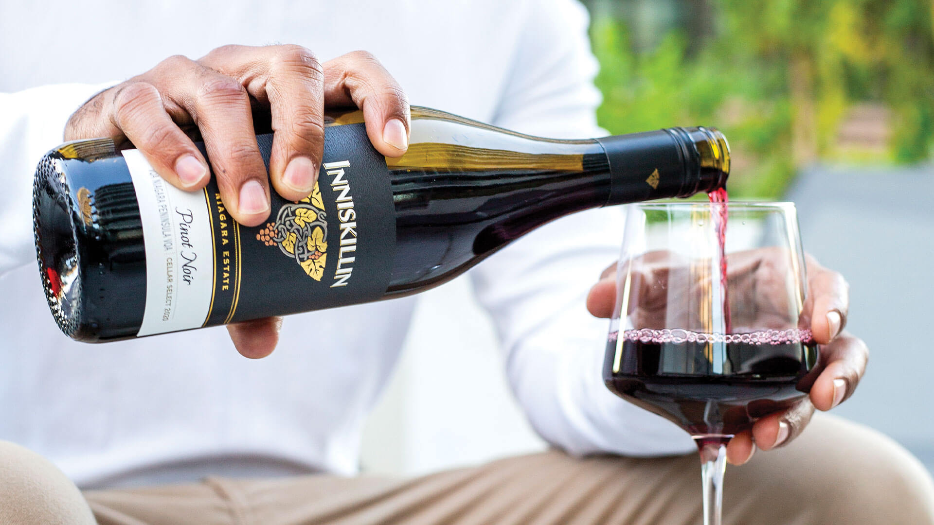 Wine lover pouring a glass of Inniskillin Pinot Noir.